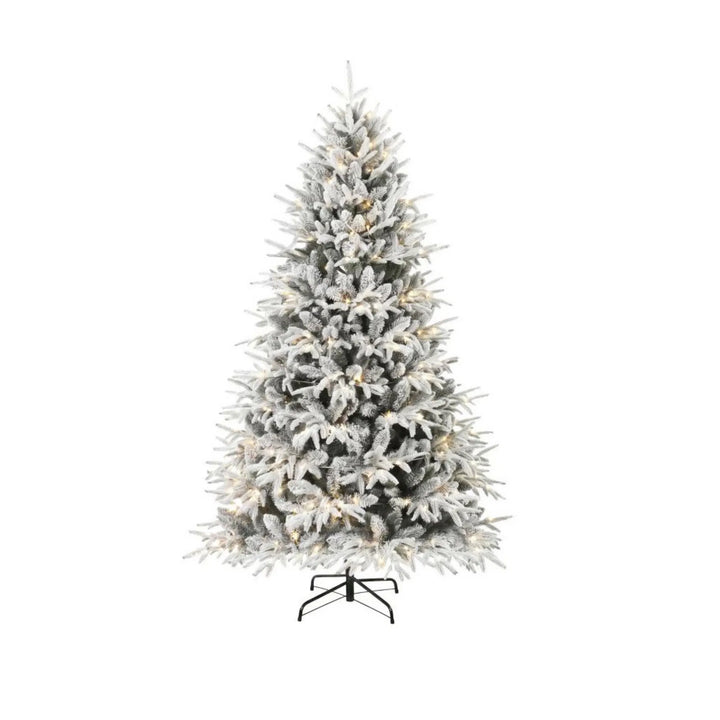 Fyldig snødekt juletre med varmhvite lys