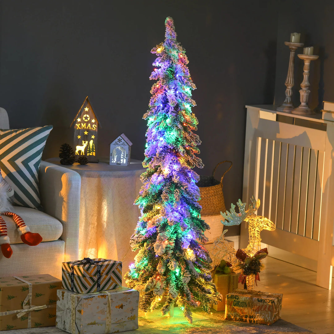 Lite smalt snødekt juletre med lys