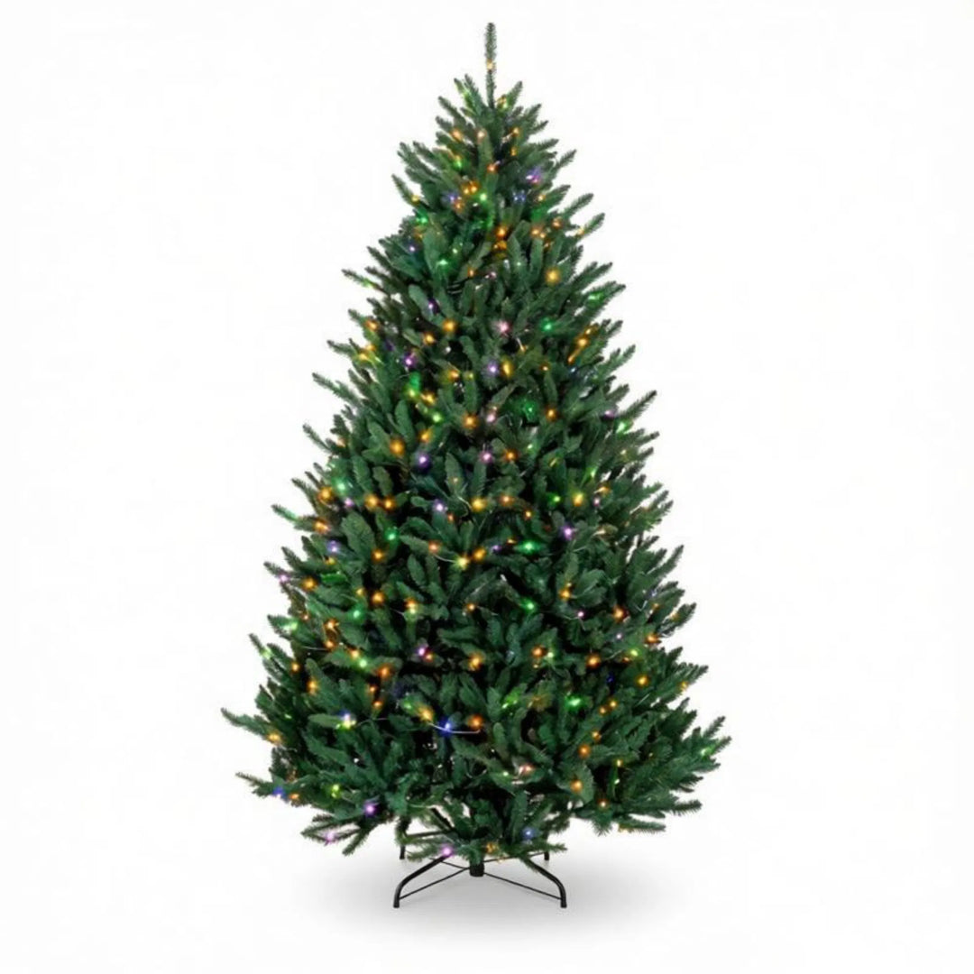Fyldig juletre med fargerike og varmhvite lys